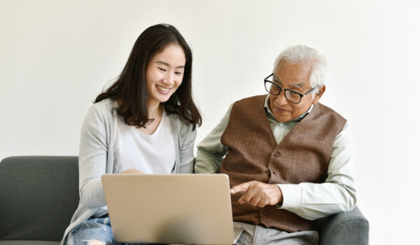 Asian family relationship, Daughter and elderly father using laptop computer together, Senior people spend time learning to use social media and digital technology platform.